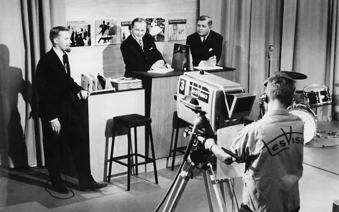 Modern newsroom with journalists working at desks and screens